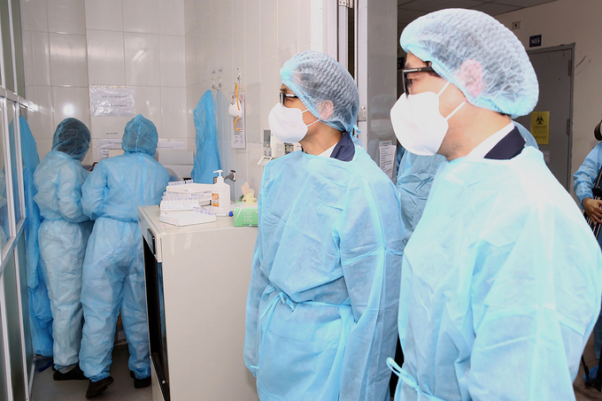Phó thủ tướng Vũ Đức Đam (thứ hai từ phải), kiểm tra một phòng xét nghiệm Covid-19 ở CDC Hà Nội. Ảnh: Đình Nam